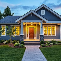 Beautiful modern suburban house with warm interior lights and elegant landscaping.